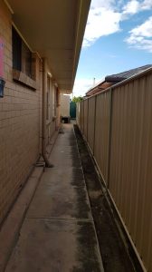 side of house showing the closeness of eaves to fence line