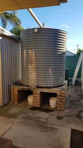 Old rainwater tank with signs of leaking on base